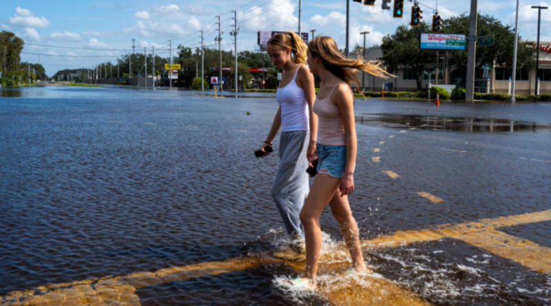 Women walk through the floodplains of Milton