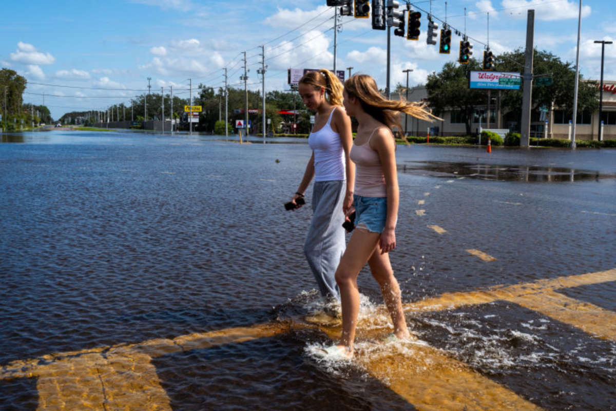 Women walk through the floodplains of Milton